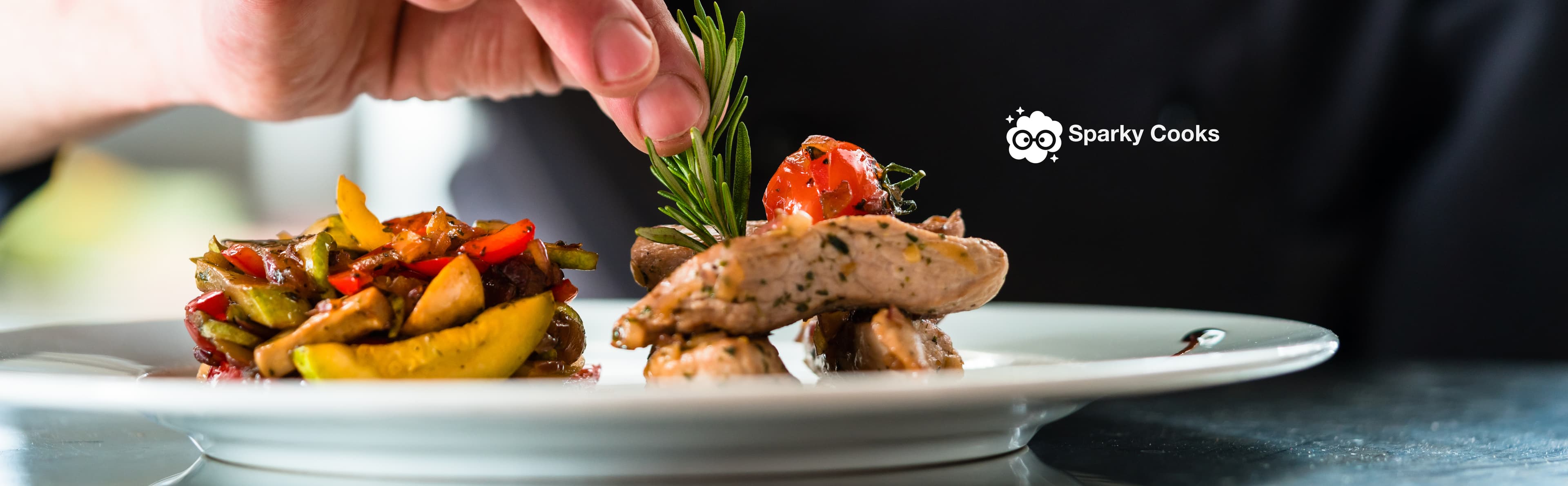 A cook adding the finishing touch to a plated meal, beside the Sparky Cooks logo